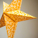 Decorative orange star-shaped lantern with intricate patterns on a light gray background