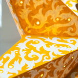 Decorative star with intricate white and gold patterns on a white background