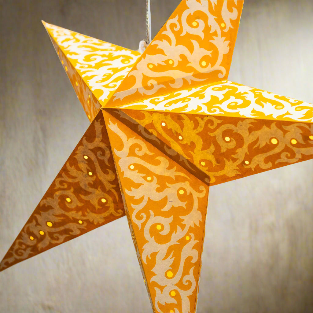 Decorative star-shaped lantern with orange and white pattern on a light blue background