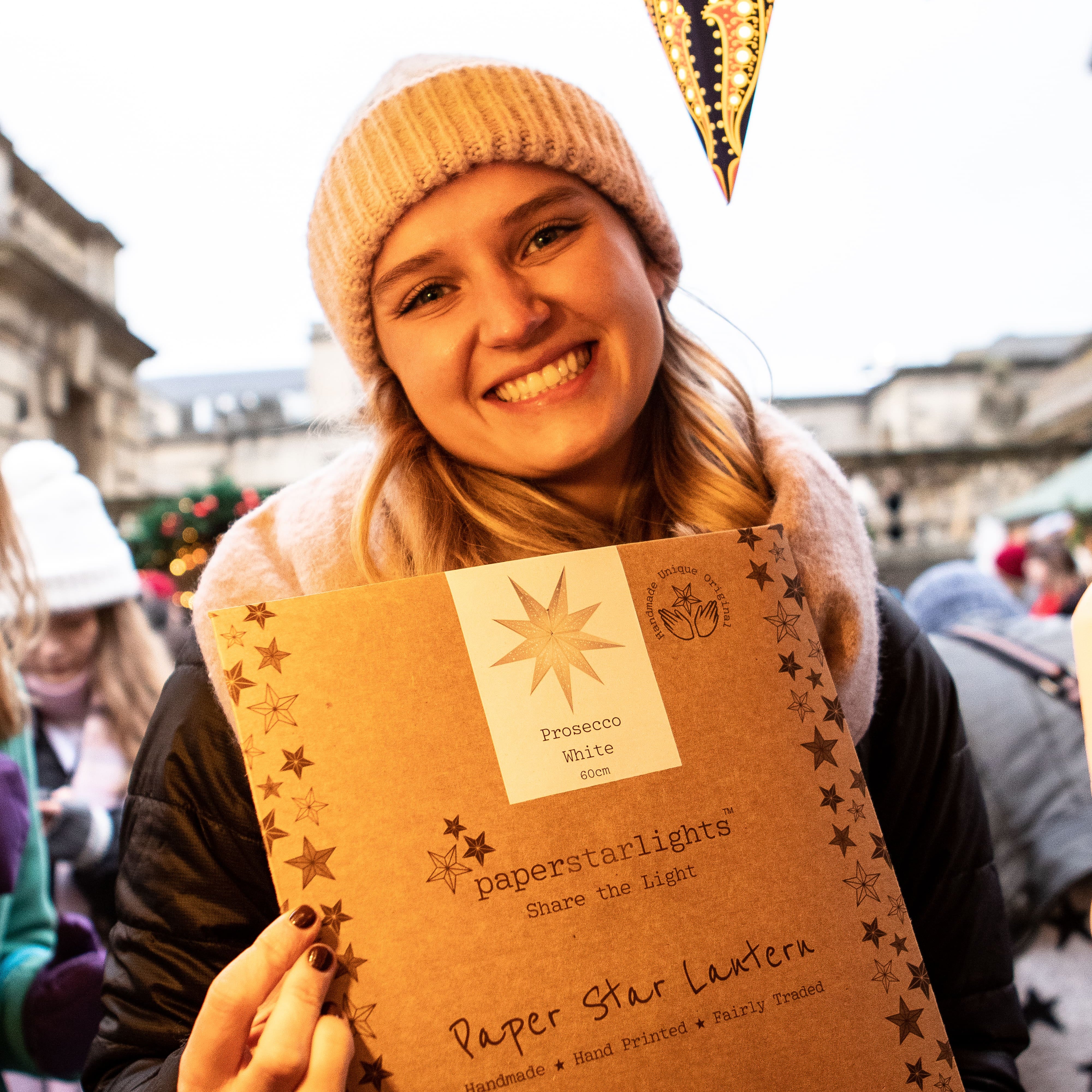 Woman holding a paper star lantern in cardboard packaging