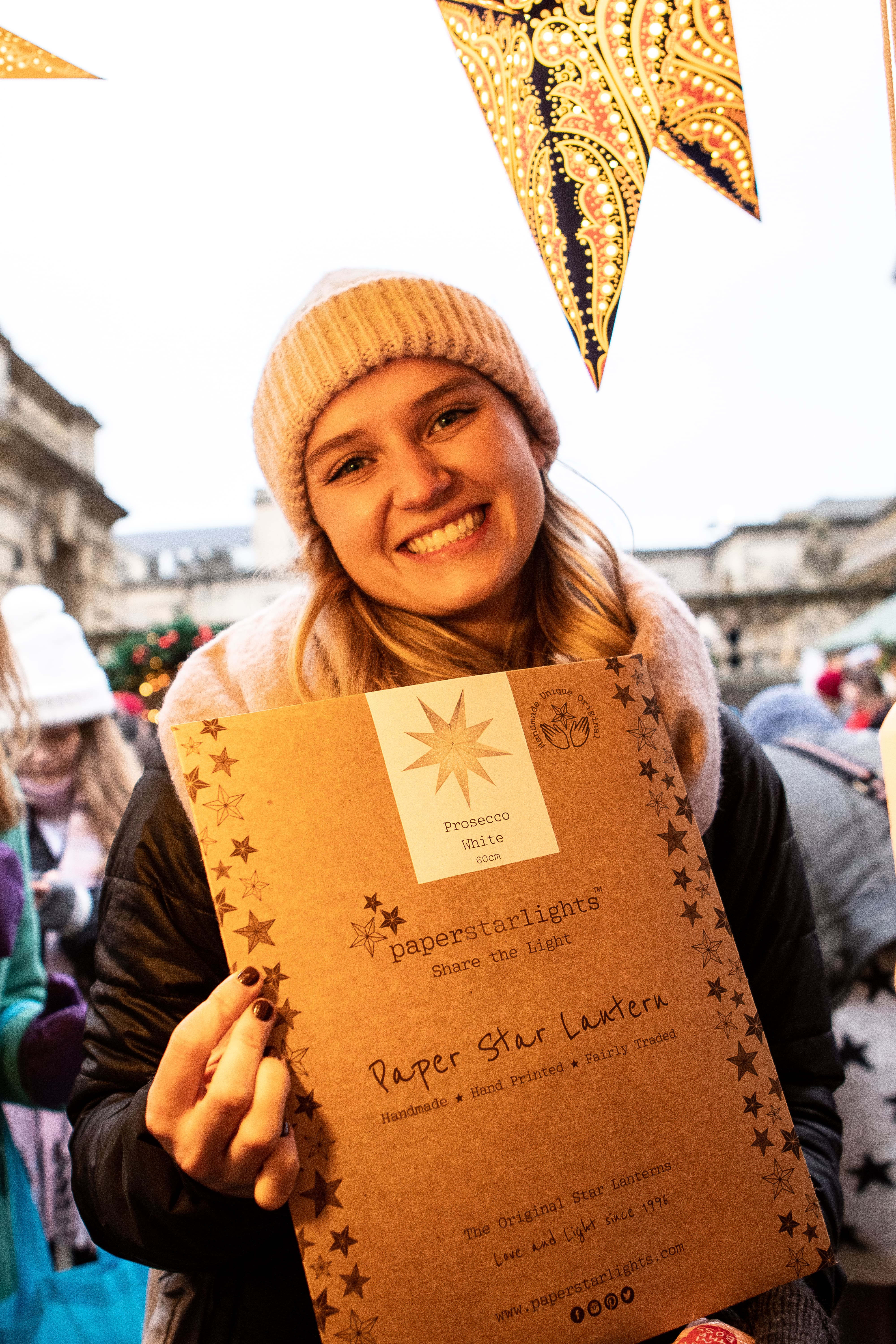 Woman holding a paper star lantern in cardboard packaging