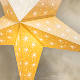 Star-shaped lamp with yellow and white design on a neutral background