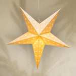 Star-shaped lantern with a warm glow on a beige background