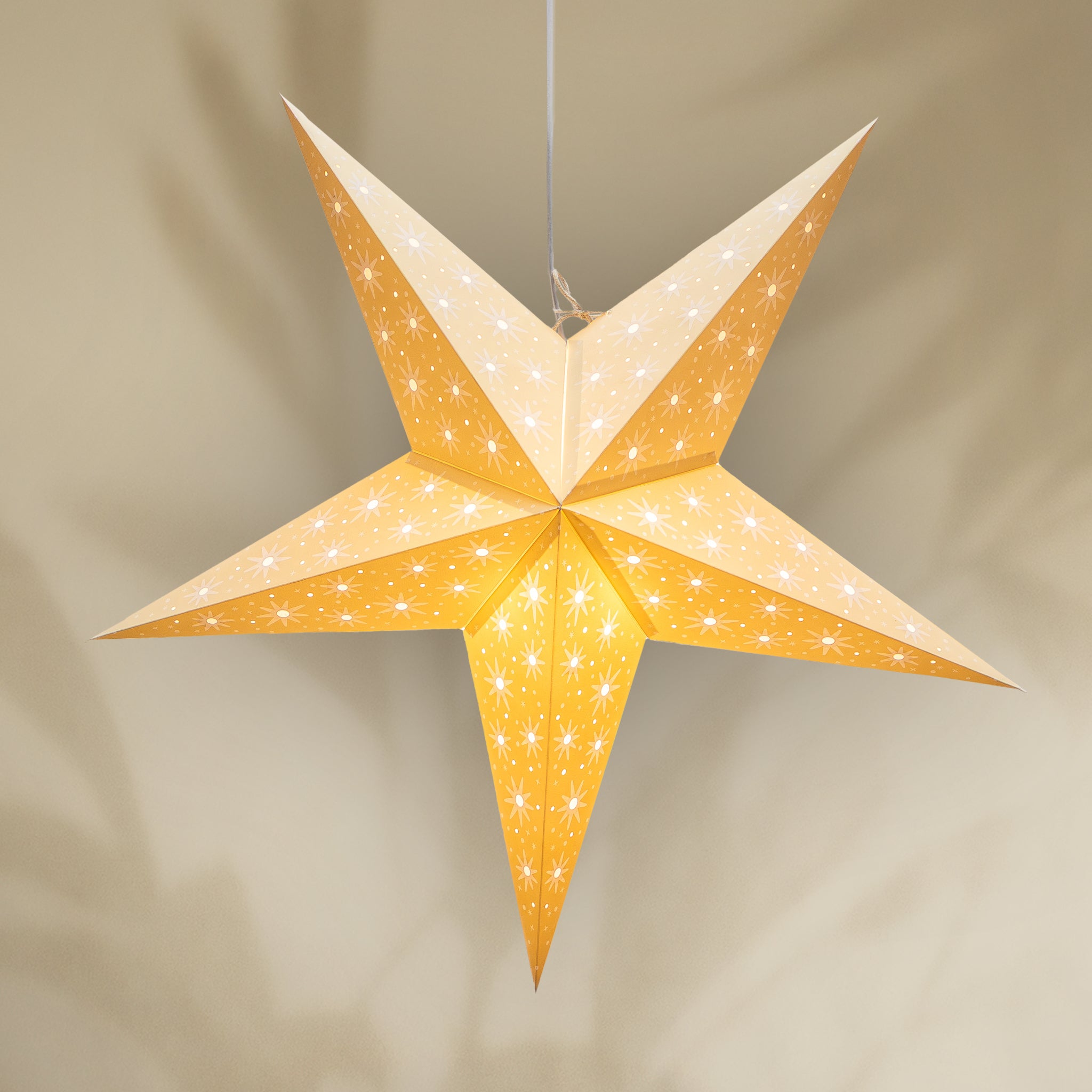 Star-shaped lantern with a warm glow on a beige background