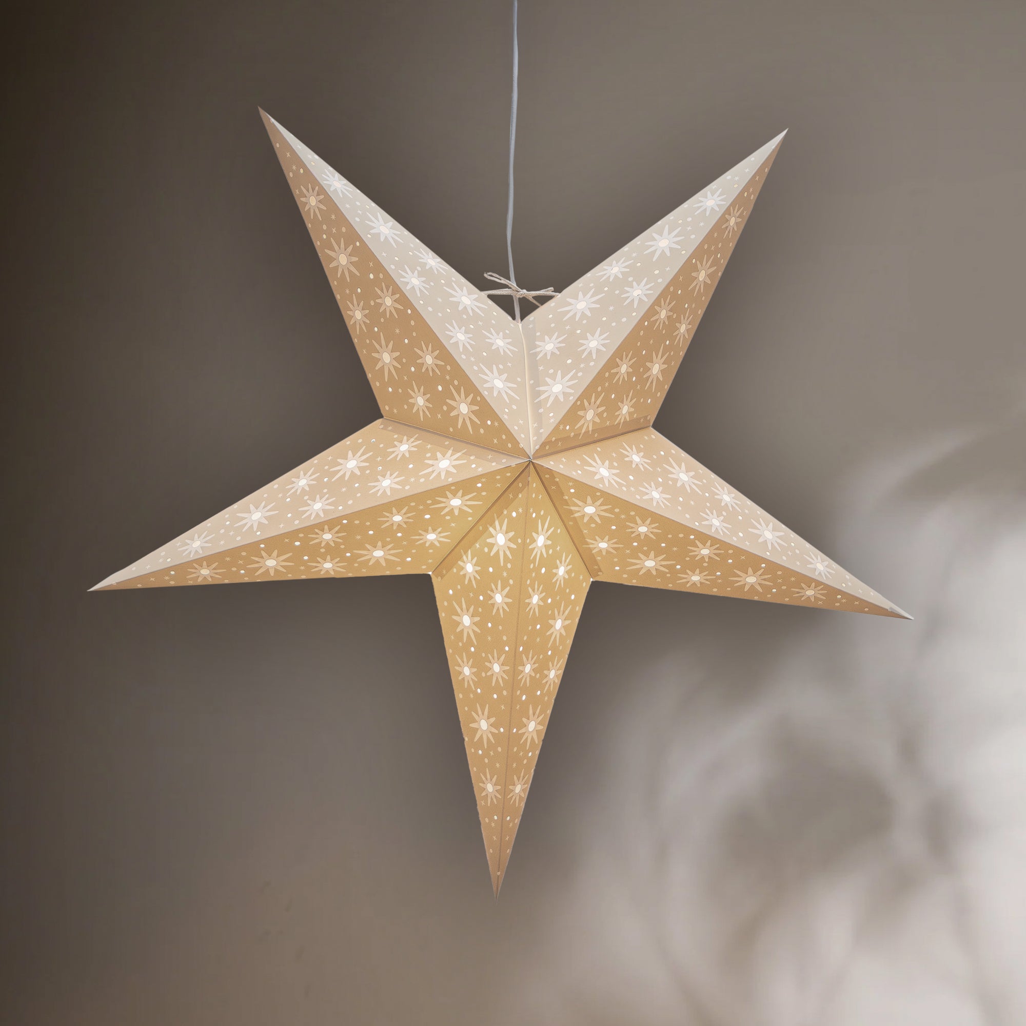 Star-shaped decorative light hanging against a neutral background