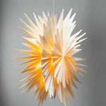 Star-shaped pendant light with a warm glow on a white background