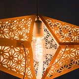 Close-up of Tiffany: Yellow paper star lantern lit from inside