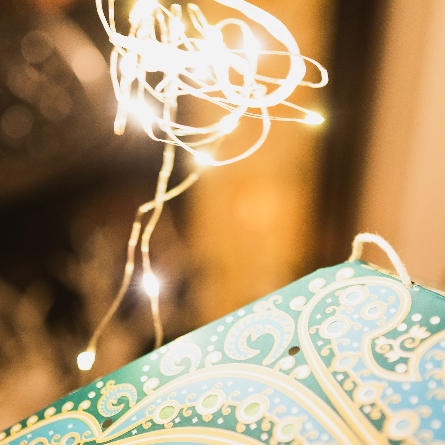 Fairy lights being placed in a blue star lantern