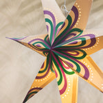 Decorative star-shaped lantern with colorful patterns on a beige background