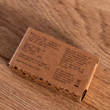 Brown rectangular box with engraved text on a wooden surface