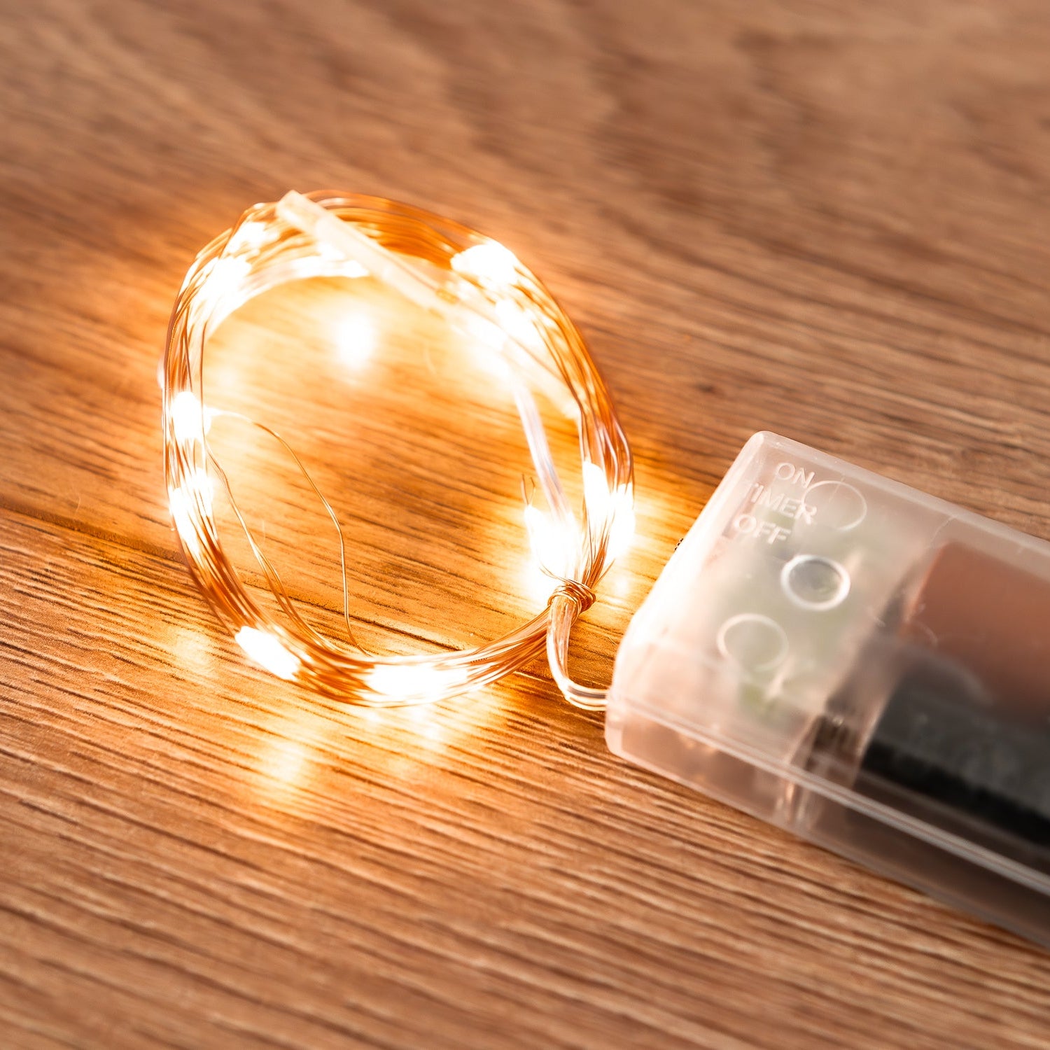 String lights with a battery pack on a wooden surface