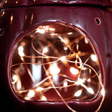 Close-up of a purple lamp with string lights inside, blurred background