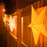 Star-shaped lights on a wooden fence at night