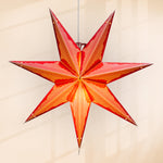 Star-shaped lamp hanging against a plain background