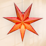 Star-shaped lamp hanging against a plain background