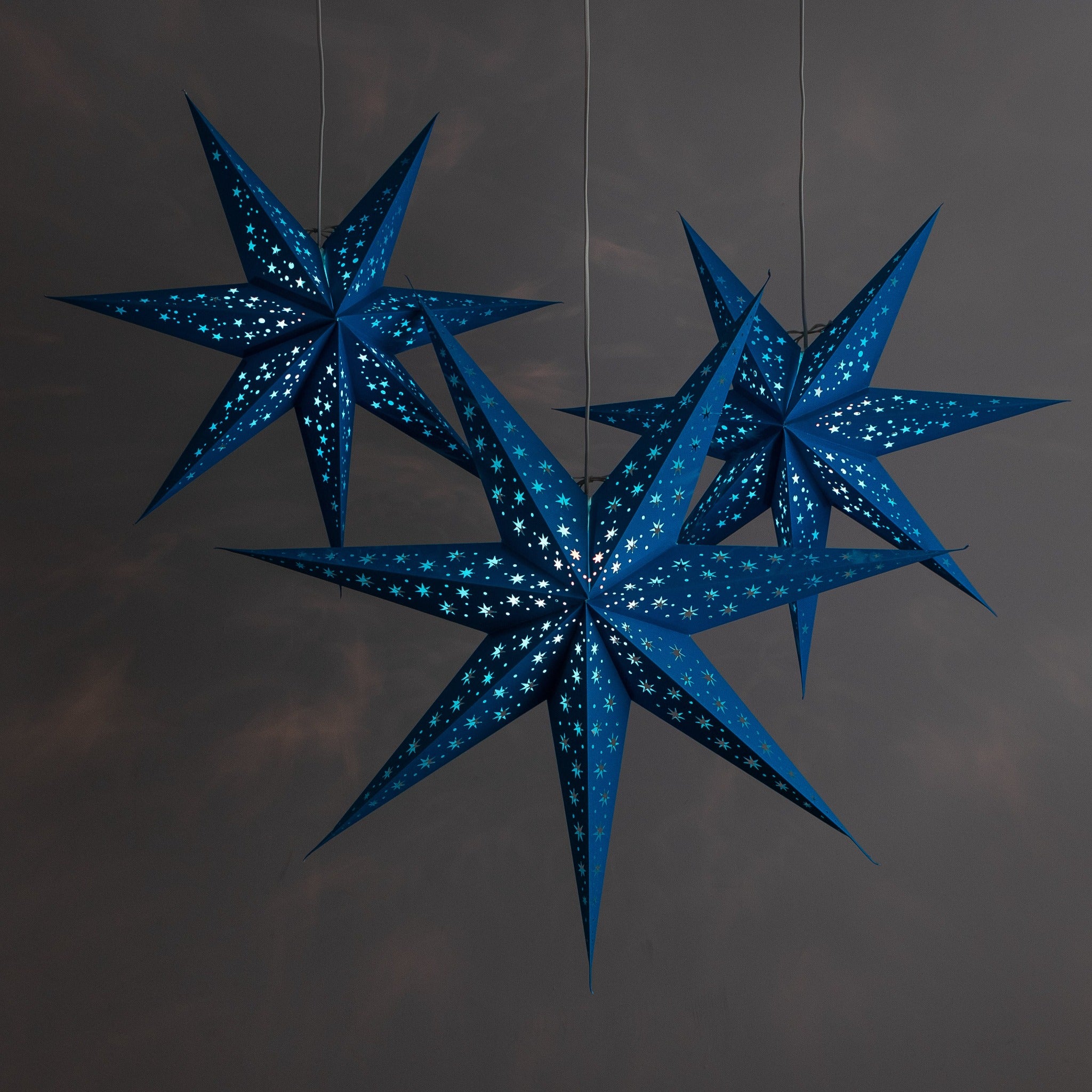 3 blue paper star lanterns illuminated